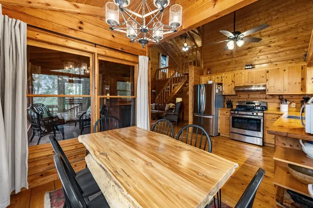 a kitchen with stainless steel appliances granite countertop a refrigerator a sink dishwasher a stove and a refrigerator with wooden floor