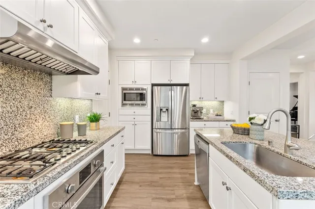 a kitchen with stainless steel appliances granite countertop a sink stove and refrigerator