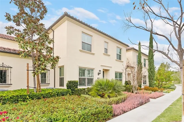 a view of a white house next to a yard and trees