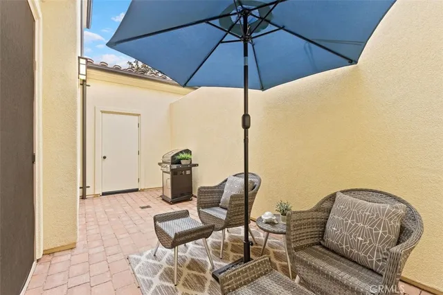a view of a terrace with furniture and an umbrella