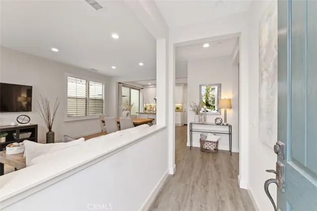a large white kitchen with wooden floor and a sink