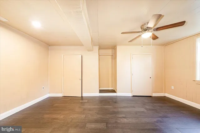 a view of an empty room with wooden floor