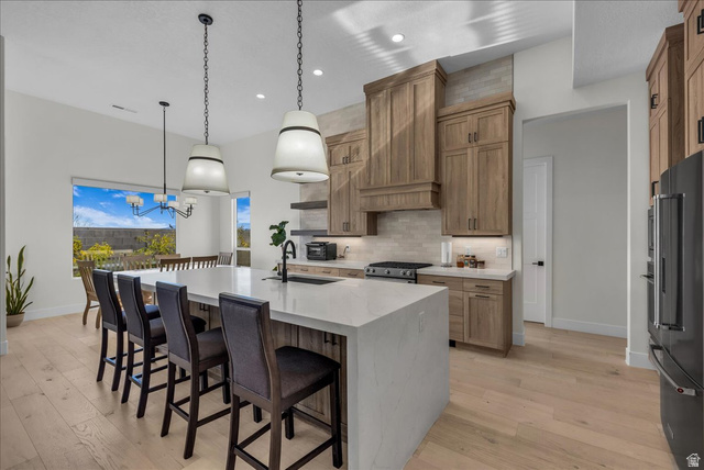 404 North Marsala Way St. George, UT 84770 - Photo 6 of 26 Kitchen featuring a breakfast bar area, light stone countertops, a large island, and stainless steel appliances