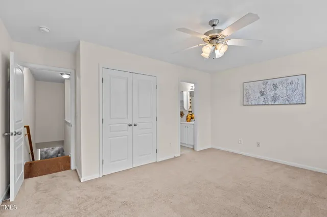 a view of an empty room with a chandelier fan