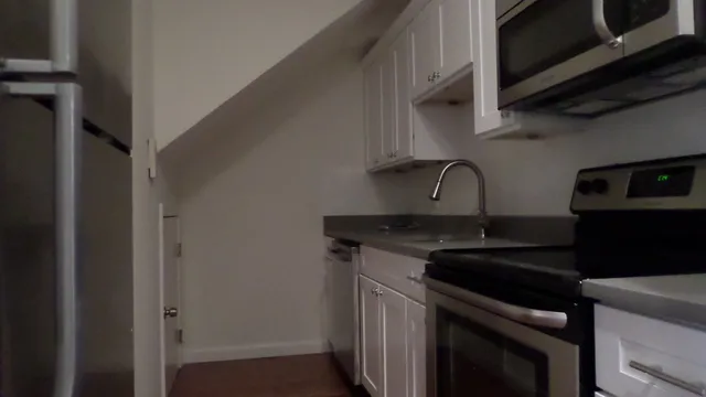 a kitchen with granite countertop a sink stainless steel appliances and cabinets