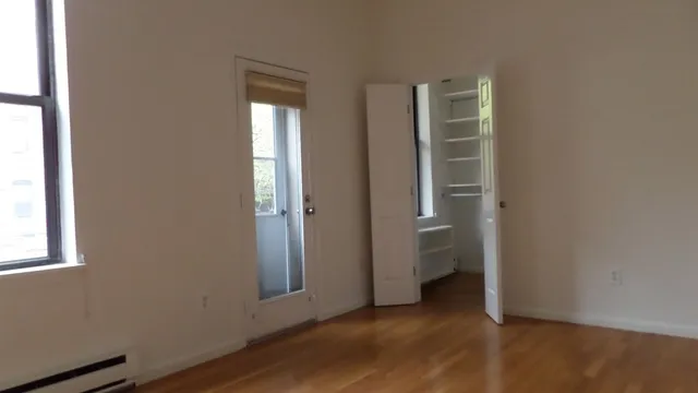 an empty room with a bathroom and a window