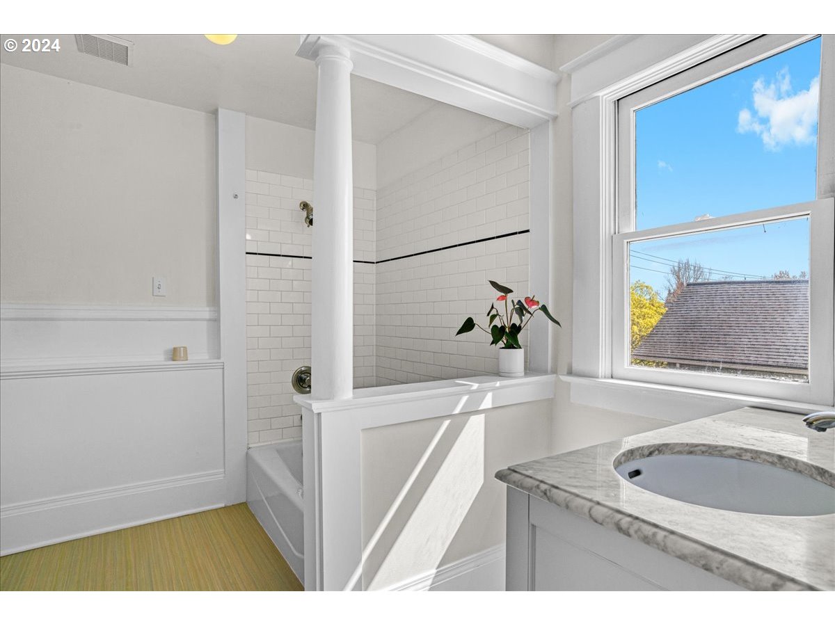 3752 Southeast Alder Street Portland, OR 97214 - Photo 24 of 44 a bathroom with a tub a sink and a window