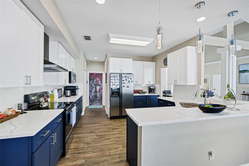 841 Grovesmere Loop Ocoee, FL 34761 - Photo 11 of 48 a kitchen with a refrigerator a stove a sink dishwasher and white cabinets with wooden floor