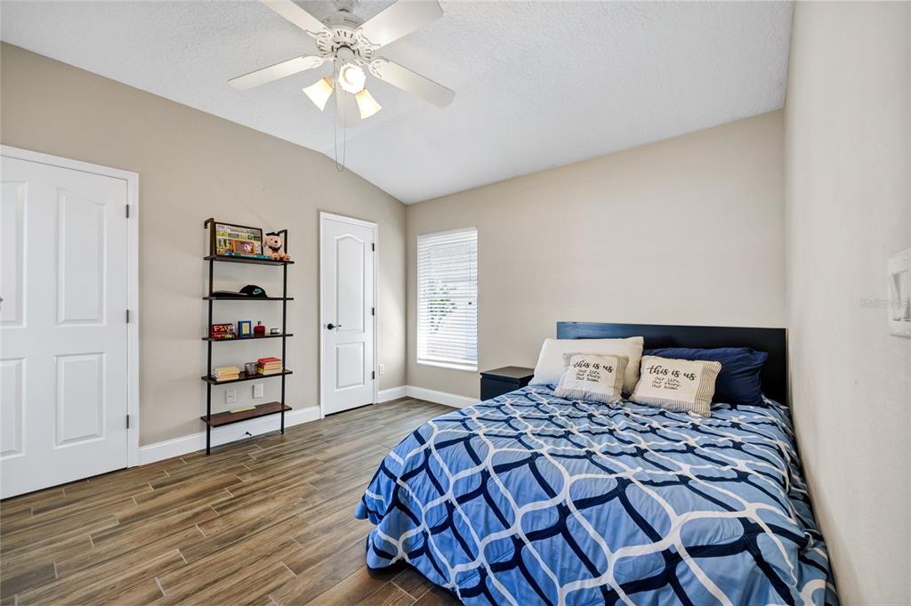 841 Grovesmere Loop Ocoee, FL 34761 - Photo 17 of 48 a bedroom with a large bed and a chandelier