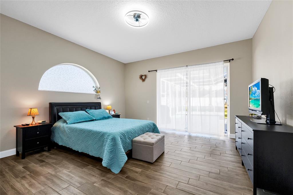 841 Grovesmere Loop Ocoee, FL 34761 - Photo 24 of 48 a bedroom with a bed and a flat tv screen on a dresser