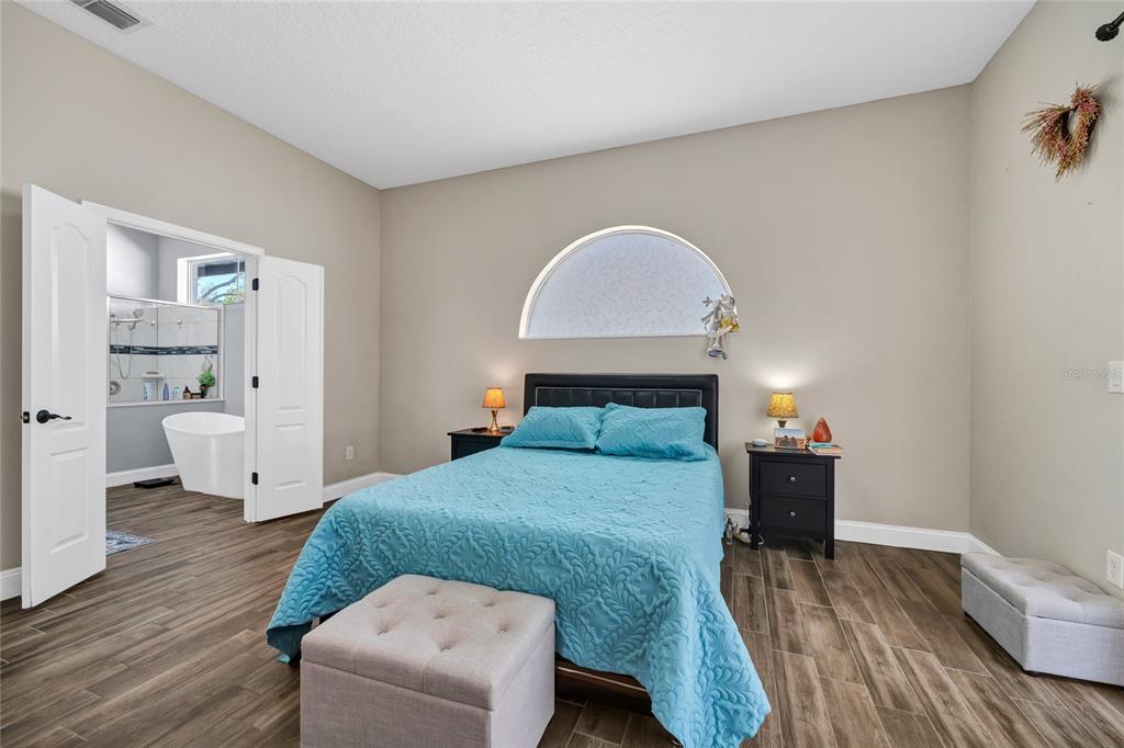 841 Grovesmere Loop Ocoee, FL 34761 - Photo 26 of 48 a bedroom with a bed and wooden floor