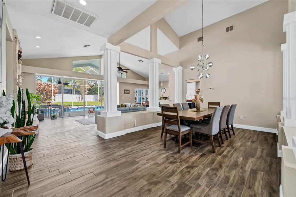 841 Grovesmere Loop Ocoee, FL 34761 - Photo 6 of 48 a dining room with wooden floor a chandelier a wooden table and chairs