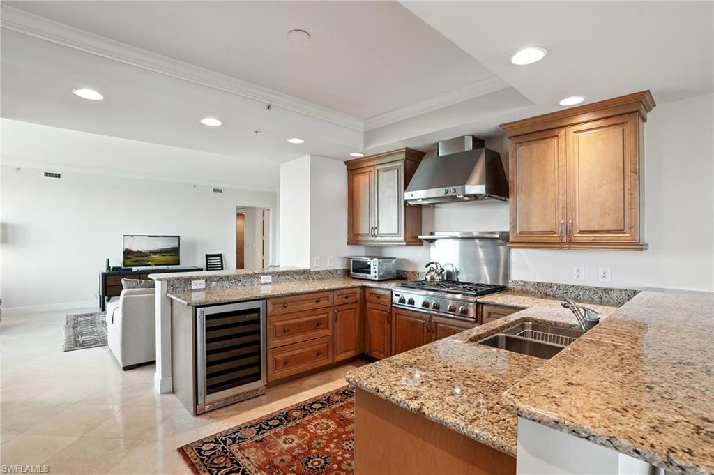 265 Indies Way, Unit 1605 Naples, FL 34110 - Photo 14 of 49 a kitchen with stainless steel appliances granite countertop a sink stove and refrigerator