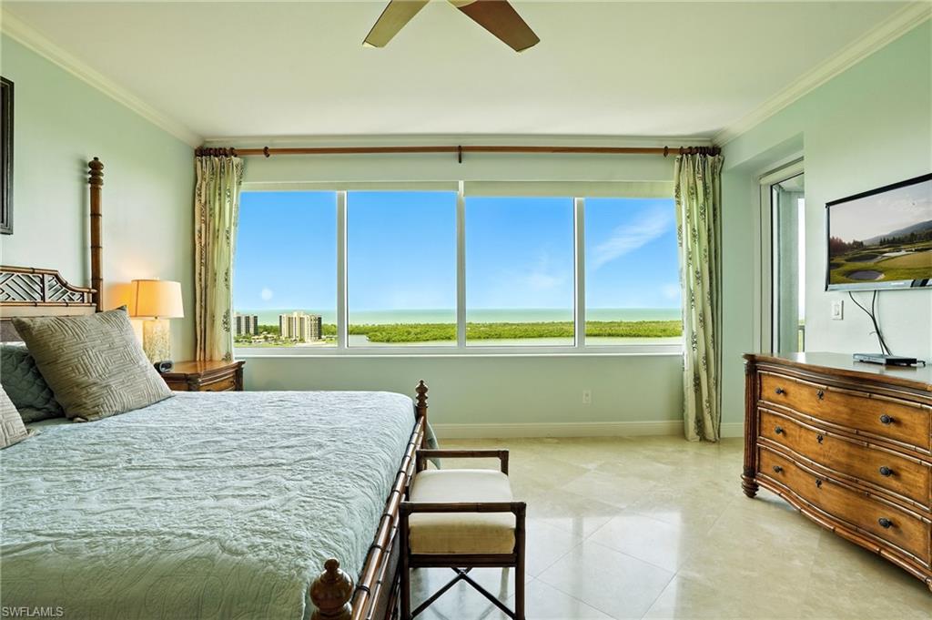 265 Indies Way, Unit 1605 Naples, FL 34110 - Photo 21 of 49 a bedroom with a bed and a dresser