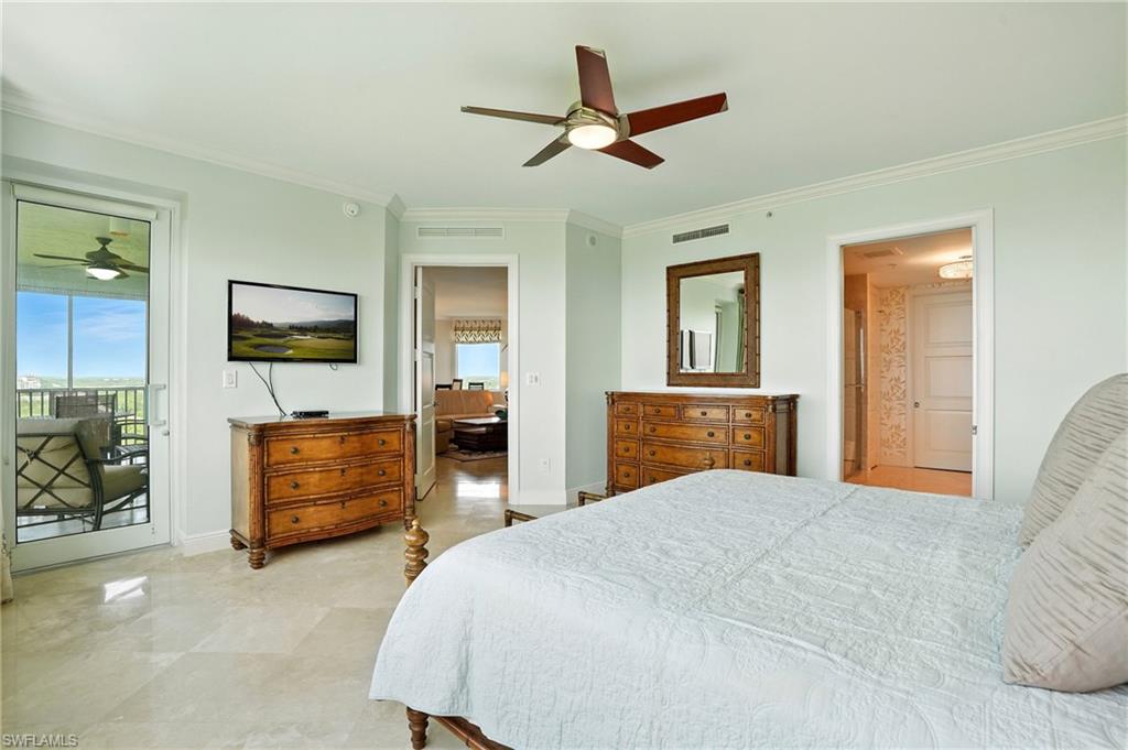 265 Indies Way, Unit 1605 Naples, FL 34110 - Photo 22 of 49 a bedroom with a bed and a chandelier