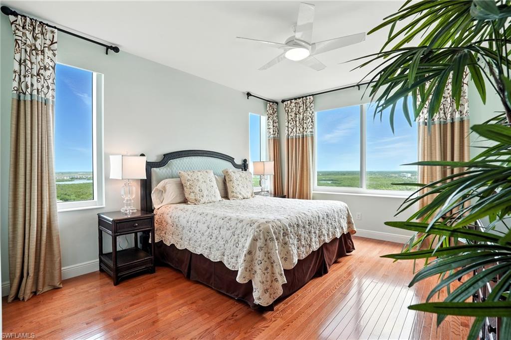 265 Indies Way, Unit 1605 Naples, FL 34110 - Photo 26 of 49 a bedroom with bed and a large window with wooden floor