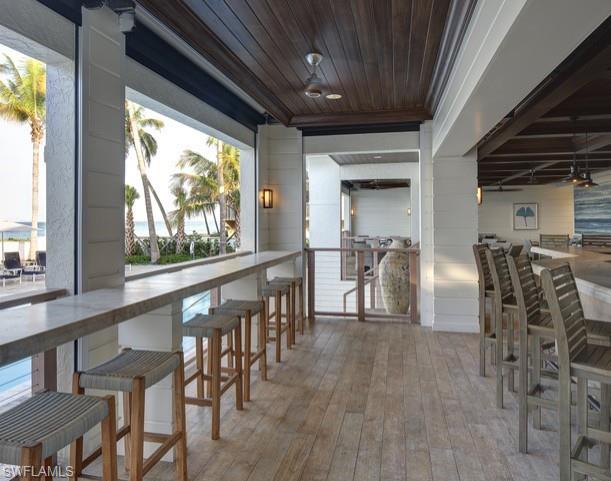 265 Indies Way, Unit 1605 Naples, FL 34110 - Photo 46 of 49 a dining room with furniture floor to ceiling windows and plants