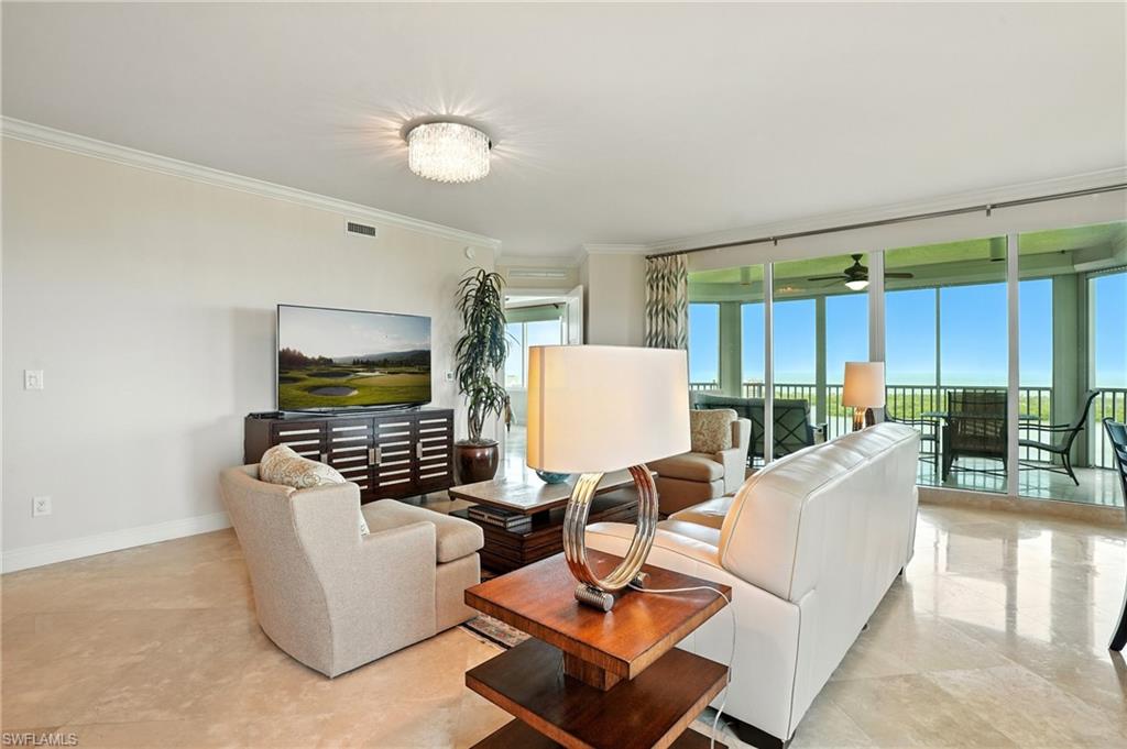 265 Indies Way, Unit 1605 Naples, FL 34110 - Photo 8 of 49 a living room with couches and kitchen view with wooden floor