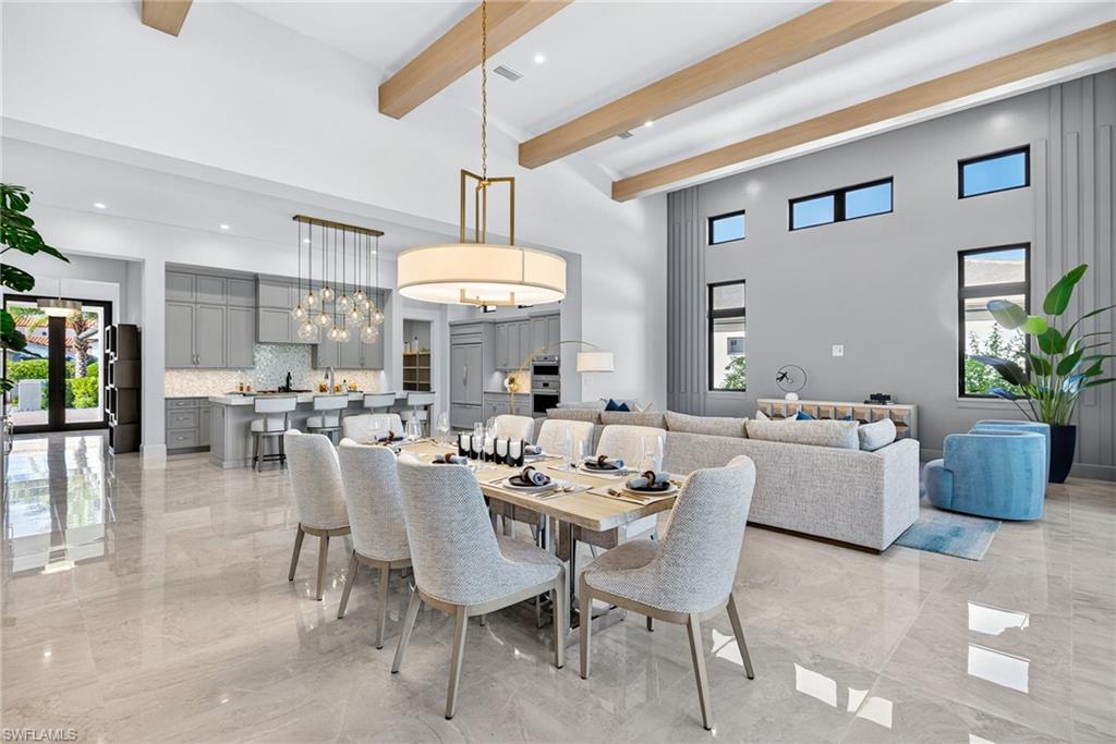 16732 Lucarno Way Naples, FL 34110 - Photo 6 of 50 Seamlessly connected to the living space, the spacious dining area comfortably accommodates large gatherings and is anchored by a contemporary chandelier