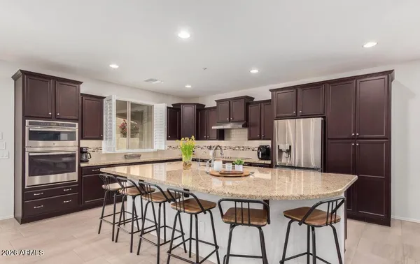 a kitchen with stainless steel appliances granite countertop a refrigerator a stove a microwave and a refrigerator