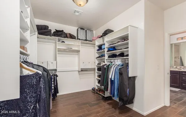 a view of walk in closet with clothes and shoes