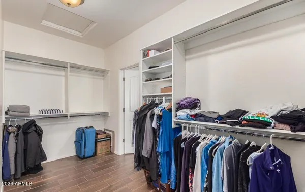 a view of walk in closet with clothes and shoes