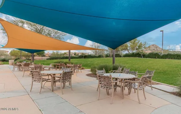 a view of a patio with chairs and table under an umbrella