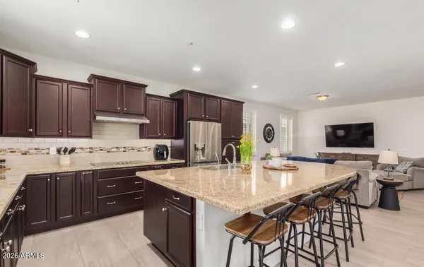 a kitchen with stainless steel appliances granite countertop a sink a stove a refrigerator and a refrigerator