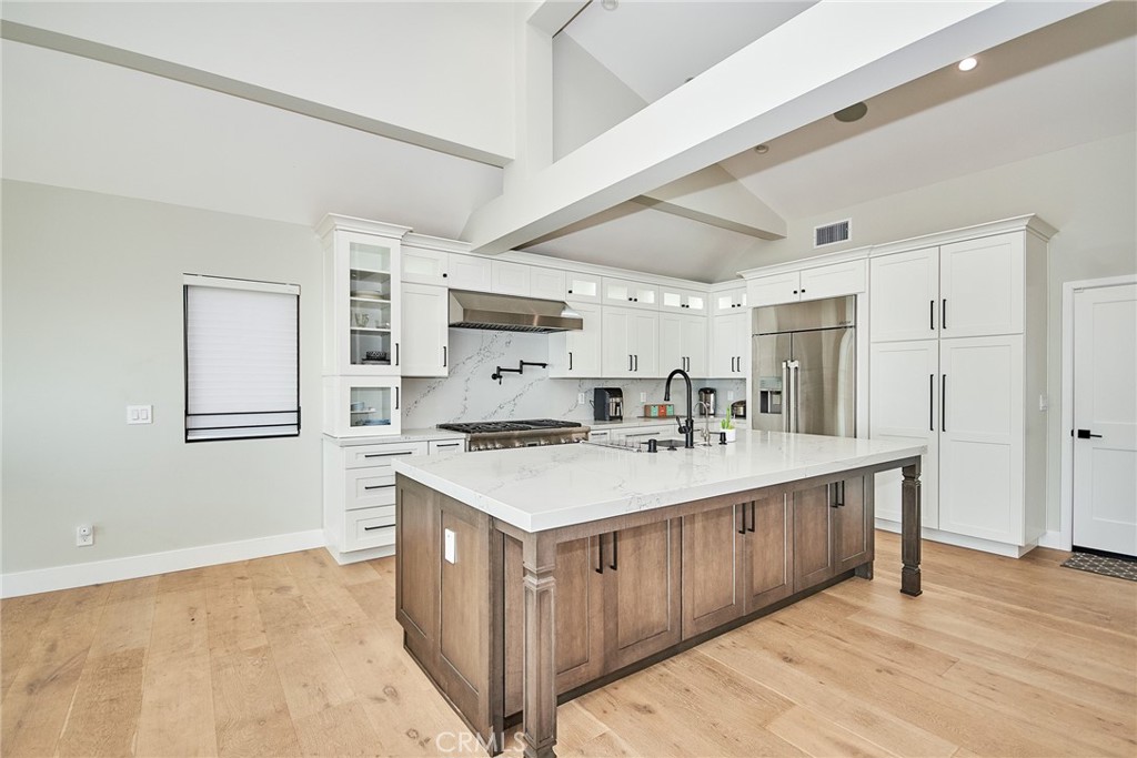 243 Notteargenta Road Pacific Palisades, CA 90272 - Photo 19 of 56 a kitchen with a sink stove and cabinets