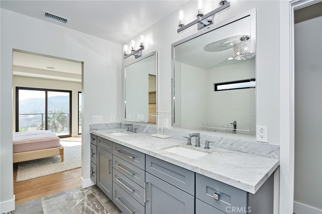 243 Notteargenta Road Pacific Palisades, CA 90272 - Photo 35 of 56 a en suite bathroom with a granite countertop sink and a mirror