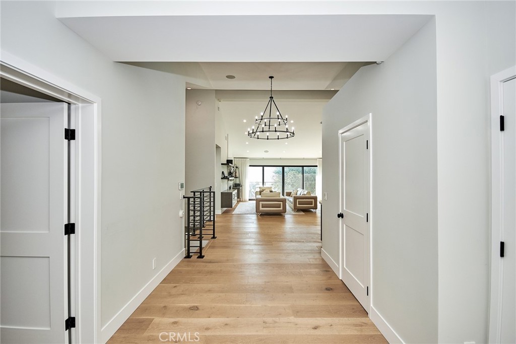 243 Notteargenta Road Pacific Palisades, CA 90272 - Photo 38 of 56 a view of a hallway with wooden floor and a living room