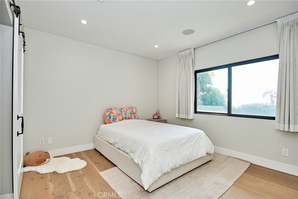 243 Notteargenta Road Pacific Palisades, CA 90272 - Photo 43 of 56 a bedroom with a bed and a large window