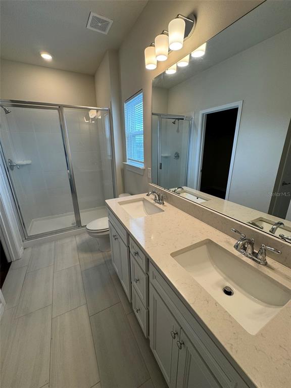 6350 Rover Way St. Cloud, FL 34771 - Photo 11 of 14 a bathroom with a sink a mirror and a shower