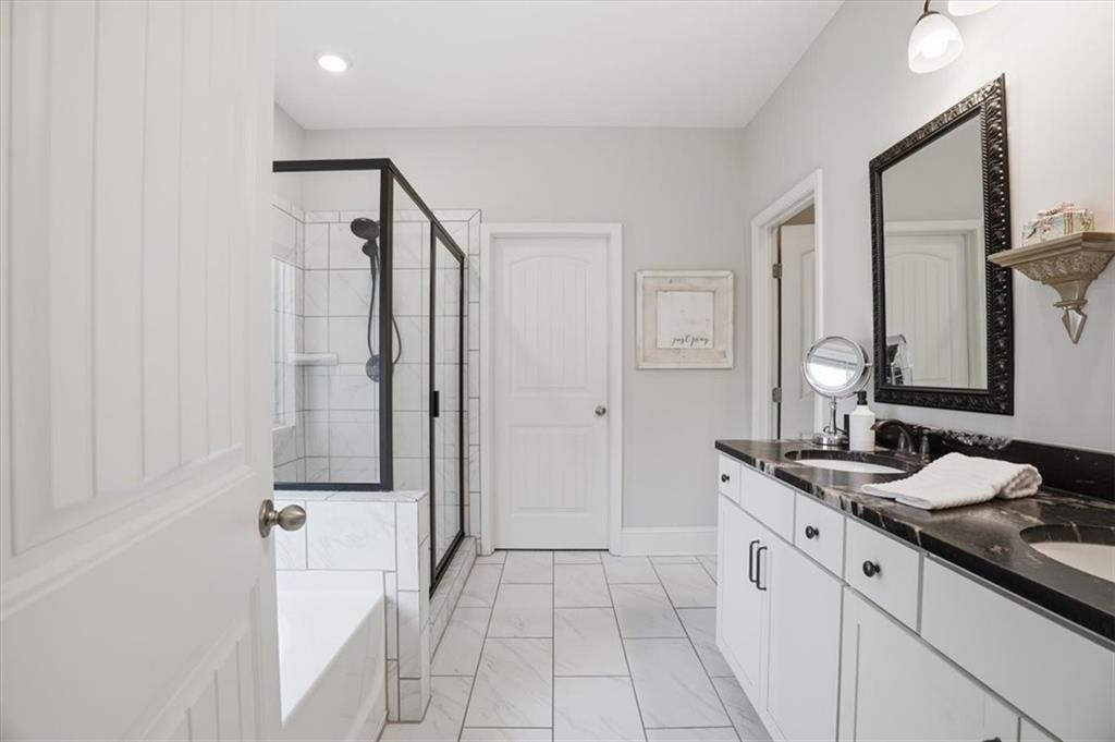 6265 Privet Way Cumming, GA 30028 - Photo 15 of 47 a spacious bathroom with a double vanity sink a mirror and a shower