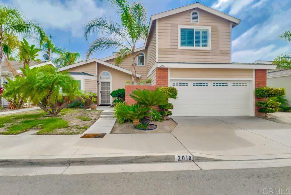 a front view of a house with a yard and a garage
