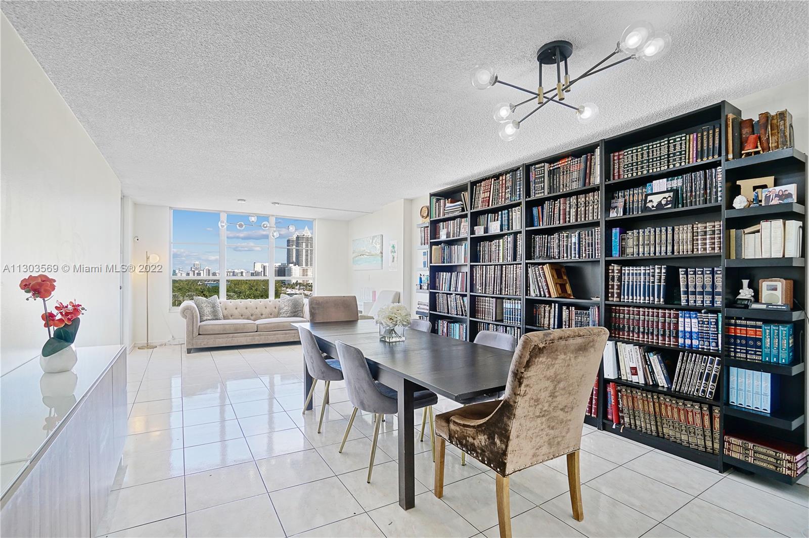 4101 Pine Tree Drive, Unit 908 Miami Beach, FL 33140 - Photo 11 of 41 a view of a livingroom with furniture and a bookshelf