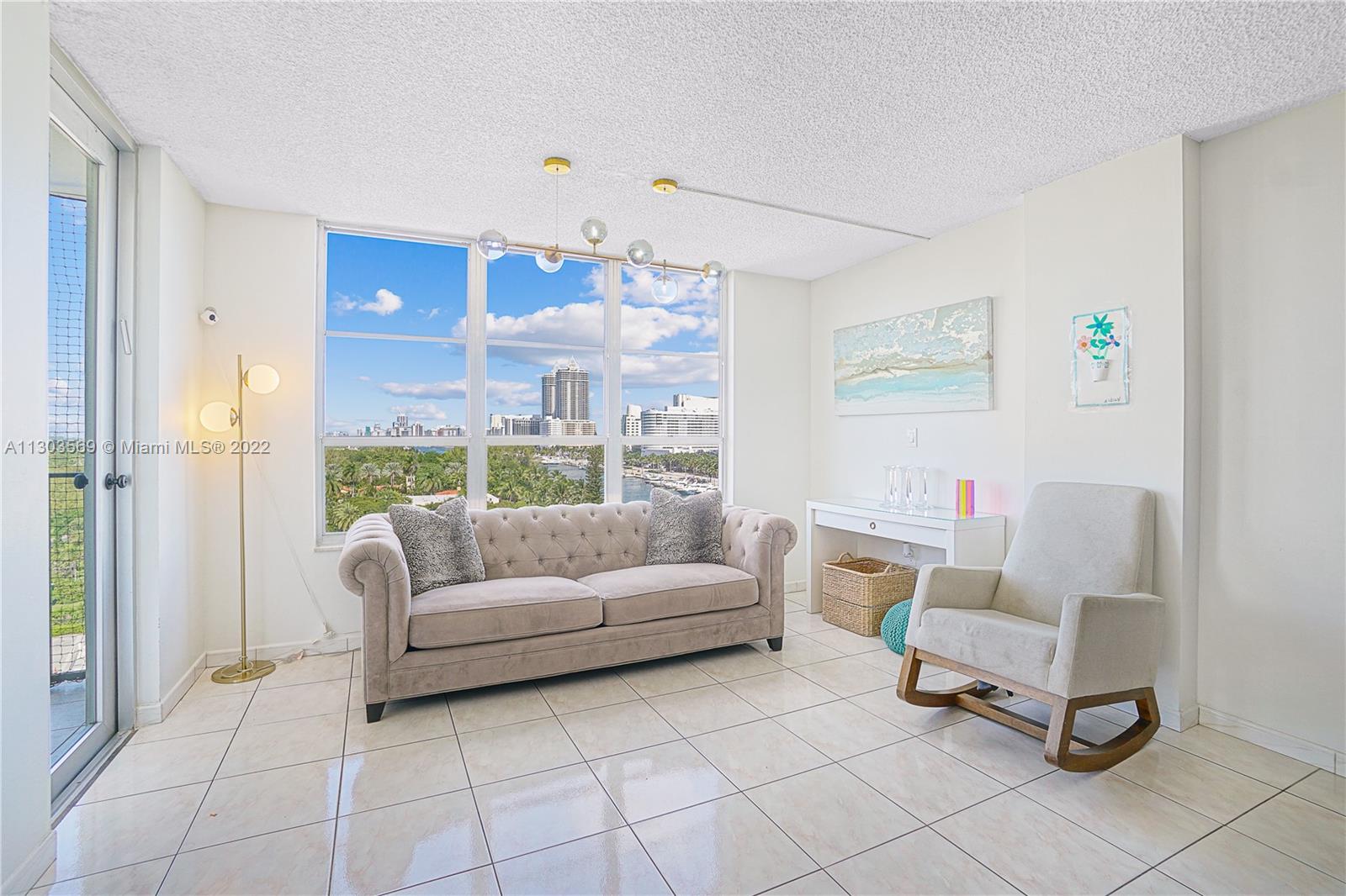 4101 Pine Tree Drive, Unit 908 Miami Beach, FL 33140 - Photo 12 of 41 a living room with furniture and a floor to ceiling window