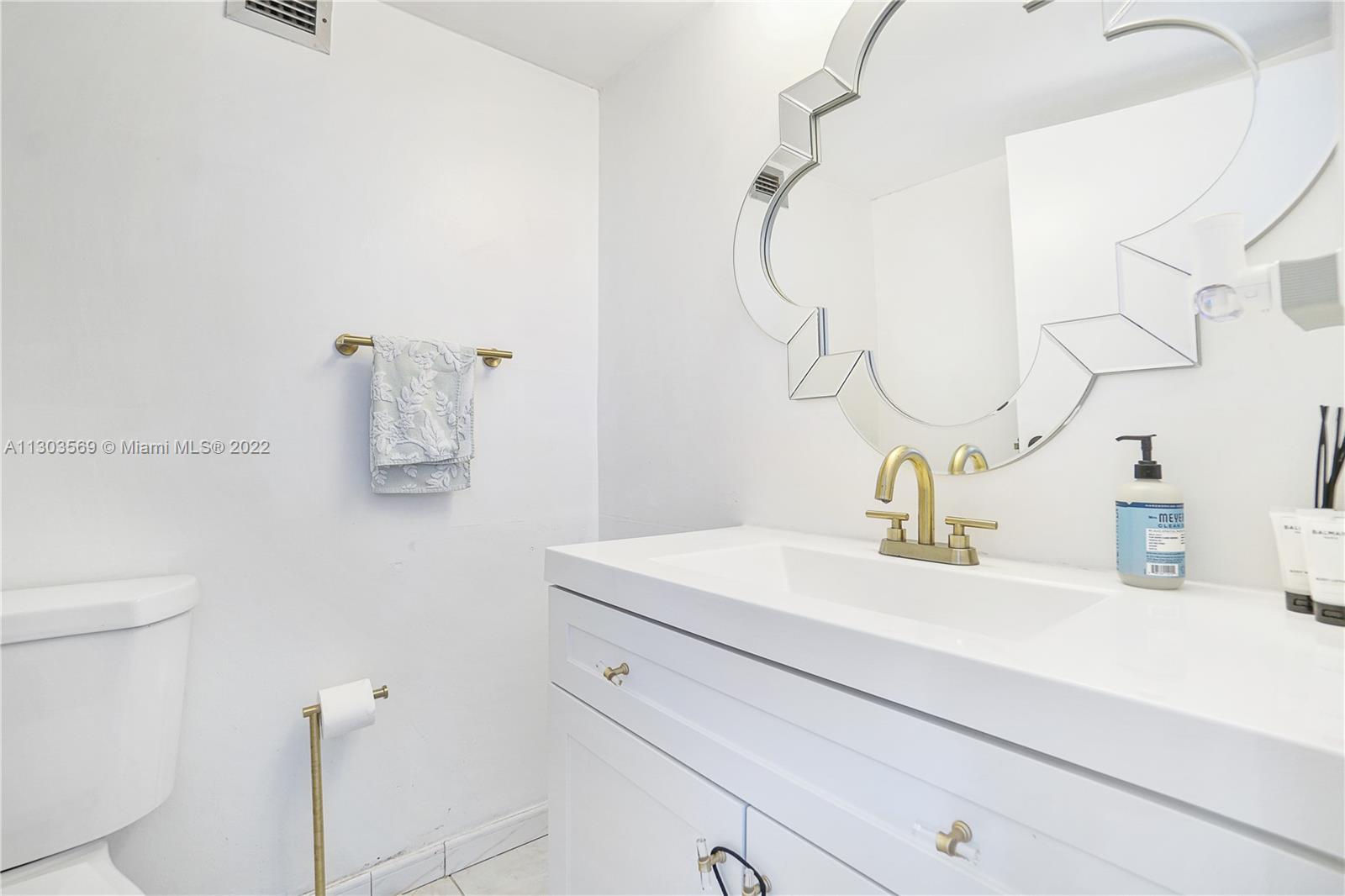 4101 Pine Tree Drive, Unit 908 Miami Beach, FL 33140 - Photo 28 of 41 a bathroom with a sink and a mirror