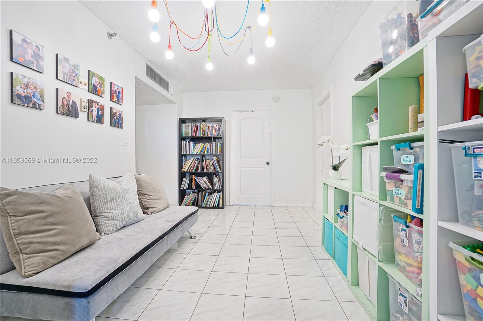 4101 Pine Tree Drive, Unit 908 Miami Beach, FL 33140 - Photo 29 of 41 a living room with furniture and a book shelf