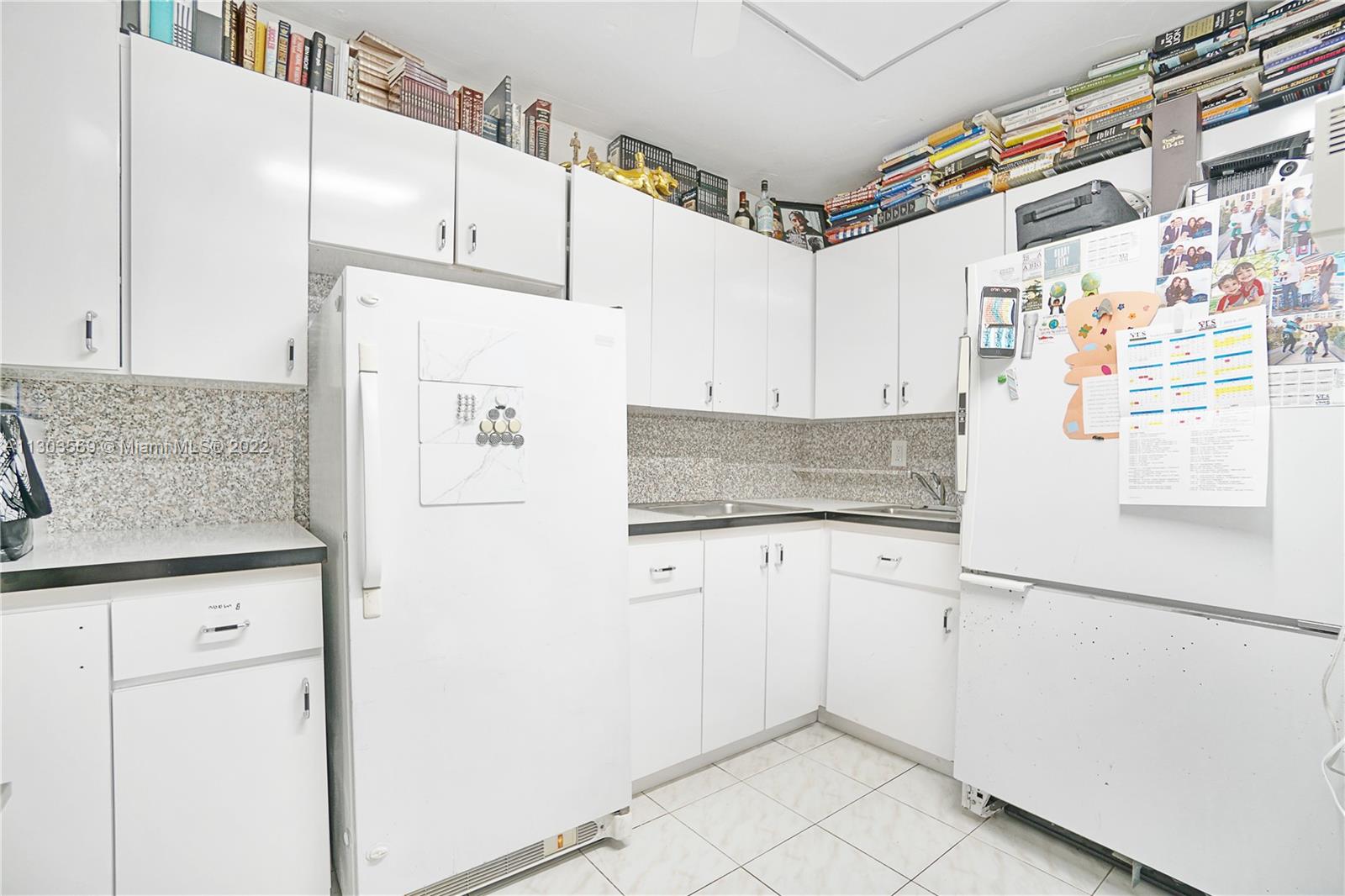 4101 Pine Tree Drive, Unit 908 Miami Beach, FL 33140 - Photo 30 of 41 a kitchen with stainless steel appliances a refrigerator and cabinets