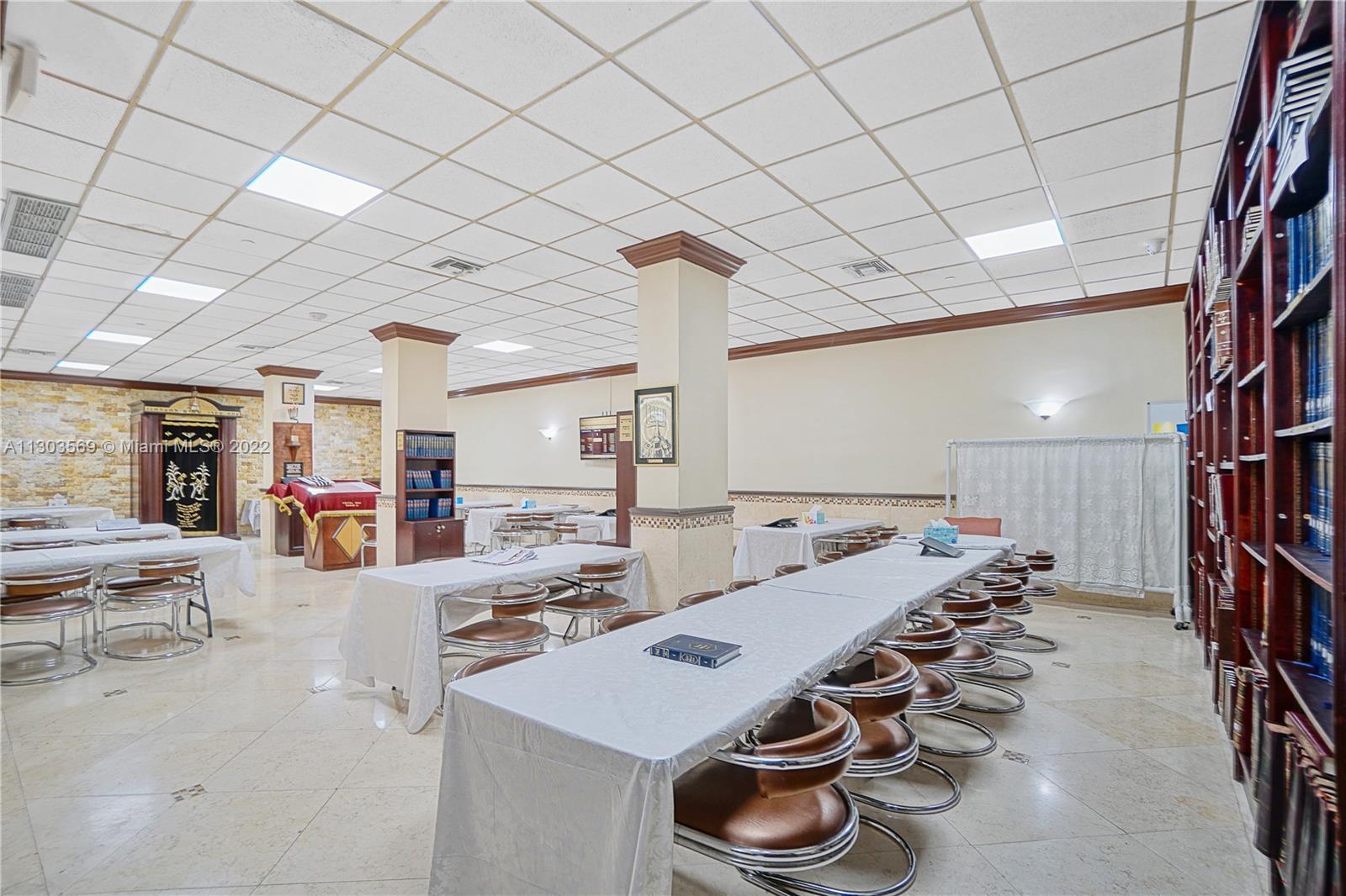 4101 Pine Tree Drive, Unit 908 Miami Beach, FL 33140 - Photo 32 of 41 a large room with lots of wooden furniture and a rug