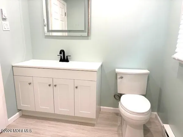 a bathroom with a toilet a sink and mirror