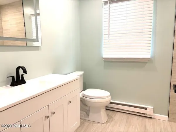 a bathroom with a sink a toilet and a window