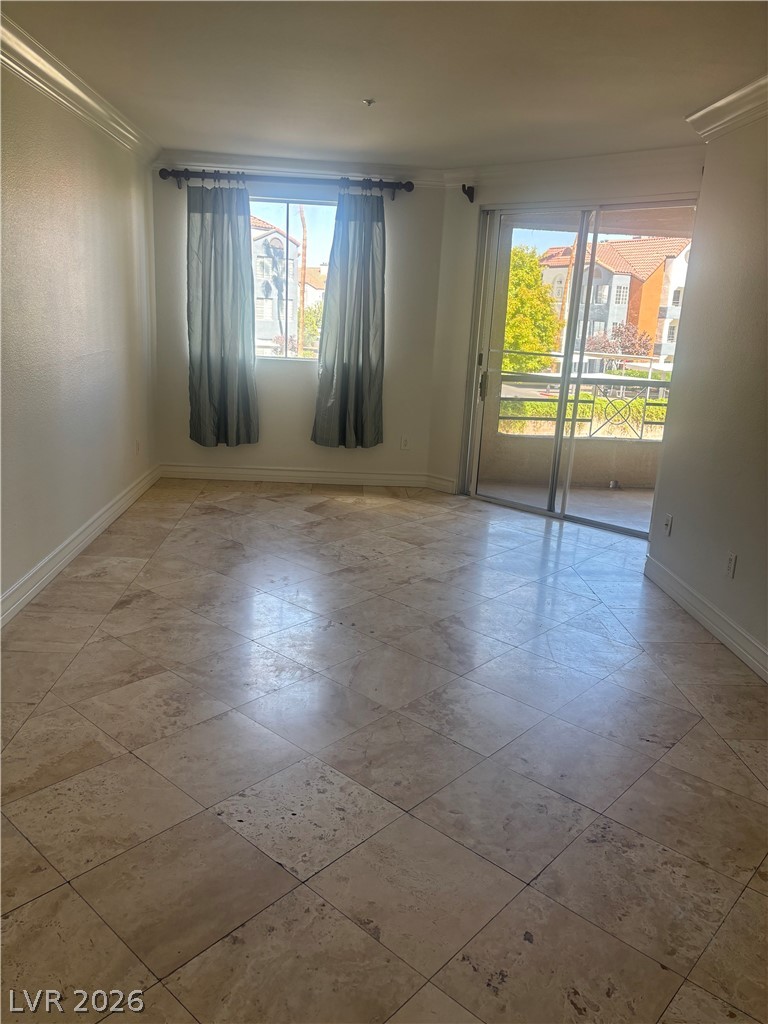 210 East Flamingo Road, Unit 123 Las Vegas, NV 89169 - Photo 4 of 17 Polished stone tile flooring and classic crown molding elevate this sunlit interior space.