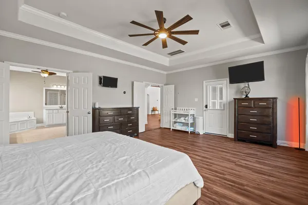 a large bedroom with a bed and a flat screen tv