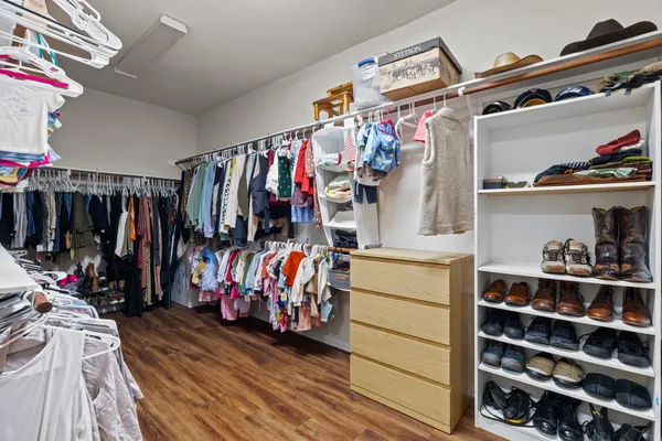 a view of walk in closet with clothes and shoes
