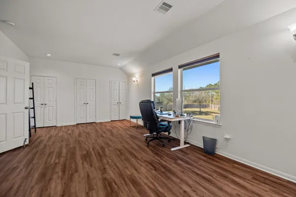 a view of a workspace with wooden floor and a window