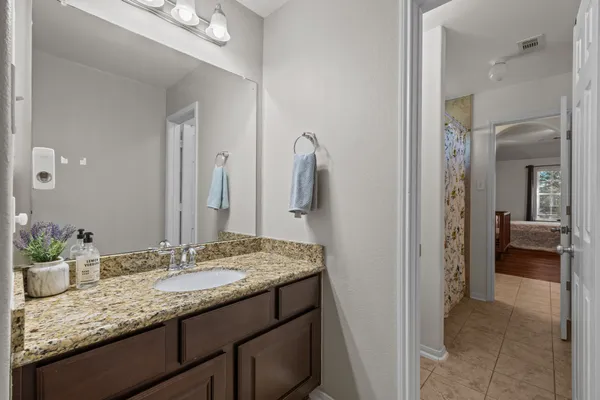a bathroom with a granite countertop sink and a mirror