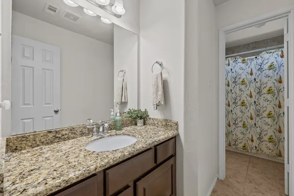 a bathroom with a granite countertop sink and a mirror