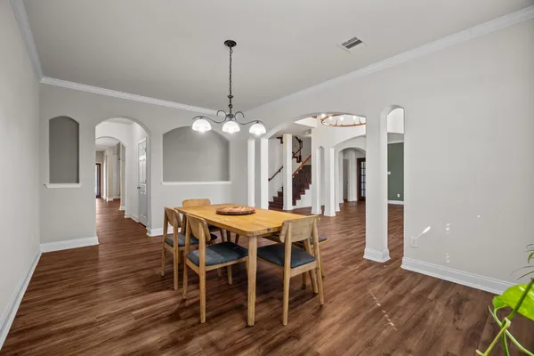 a view of a dining room with furniture a chandelier and wooden floor